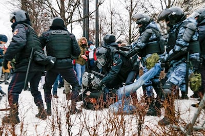 Riot police detain a demonstrator with a bloody face during a protest against the jailing of opposition leader Alexei Navalny in Pushkin square in Moscow, Russia, Saturday, Jan. 23, 2021. Russian police arrested more than 3,400 people Saturday in nationwide protests demanding the release of opposition leader Alexei Navalny, the Kremlin's most prominent foe, according to a group that counts political detentions. In Moscow, an estimated 15,000 demonstrators gathered in and around Pushkin Square in the city center, where clashes with police broke out and demonstrators were roughly dragged off by helmeted riot officers to police buses and detention trucks. Some were beaten with batons. (AP Photo/Alexander Zemlianichenko)