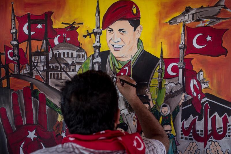 A man puts the finishing touches on a painting depicting the events of the July 15, 2016 coup attempt at an anniversary site set up to mark one year since the failed putsch in Taksim Square, Istanbul, on July 12, 2017. Chris McGrath / Getty Images