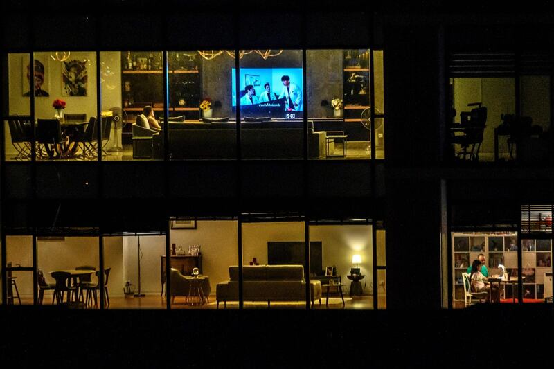 This picture taken on March 23, 2020 shows people in their apartments, amid fears over the spread of the COVID-19 novel coronavirus, in central Bangkok. / AFP / Mladen ANTONOV
