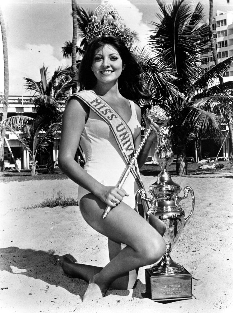 Posing with some of her prizes, Georgia Risk, Miss Universe 1971, smiles for the photographer.  Although Miss Universe no longer receives a trophy or sceptor, she does receive a specially designed Hoya Crystal statue. Courtesy Miss Universe