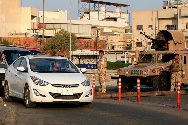 Iraqi security forces stand guard at a checkpoint in Basra.AP Photo