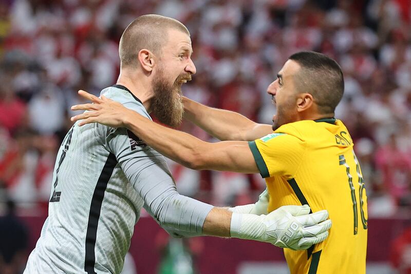 Australia's goalkeeper Andrew Redmayne (L) celebrates with Australia's defender Aziz Behich after winning the FIFA World Cup 2022 inter-confederation play-offs match between Australia and Peru on June 13, 2022, at the Ahmed bin Ali Stadium in the Qatari city of Ar-Rayyan.  (Photo by KARIM JAAFAR  /  AFP)