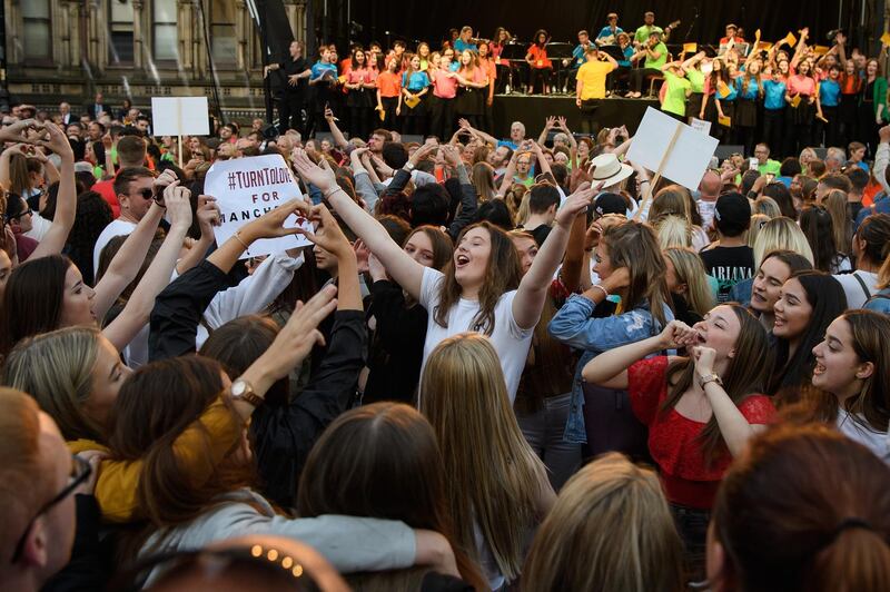 A group of young women sing and dance during the Manchester Together - With One Voice tribute concert at Albert Square. Leon Neal/Getty Images