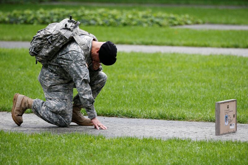 US Army Reserve Sgt Edwin Morales kneels as he honors his cousin Ruben Correa during the ceremonies at the National 9/11 Memorial and Museum in New York. Reuters