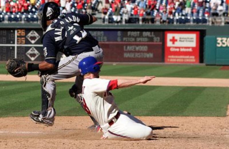 Mike Fontenot slides past Milwaukee's Martin Maldonado to score the winning run for Philadelphia