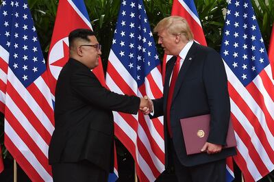 North Korea's leader Kim Jong Un (L) shakes hands with US President Donald Trump (R) after taking part in a signing ceremony at the end of their historic US-North Korea summit, at the Capella Hotel on Sentosa island in Singapore on June 12, 2018. - Donald Trump and Kim Jong Un became on June 12 the first sitting US and North Korean leaders to meet, shake hands and negotiate to end a decades-old nuclear stand-off. (Photo by Anthony WALLACE / POOL / AFP)