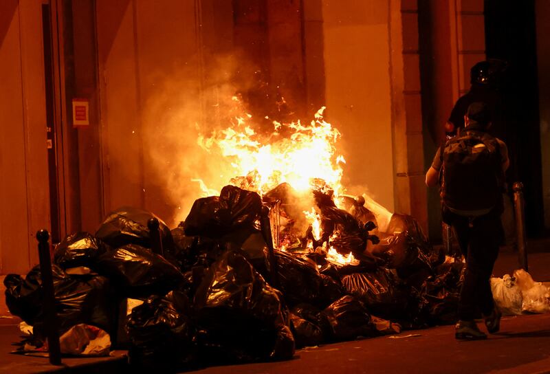 A fire lit during a demonstration in Paris as the French Parliament prepared to vote against two no-confidence motions. Reuters