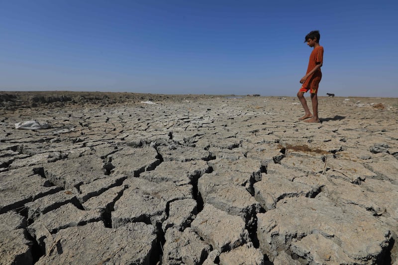 A boy walks on the dried-up bed of a section of Iraq's southern marshes of Chibayish in Dhi Qar province. AFP