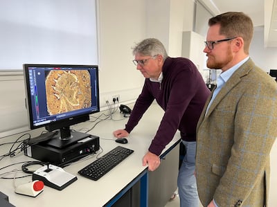 Professor Paul N Pearson, UCL, left, and Jesper Ericsson, The Hunterian, University of Glasgow look at the Sponsian gold coin under a microscope. Photo: The Hunterian, University of Glasgow