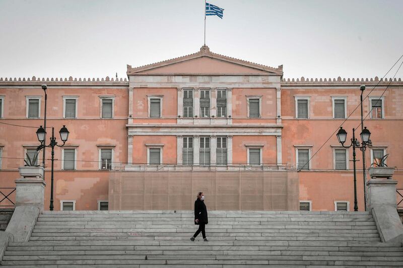A woman walks in front of the Greek Parliament in Athens, Greece. AFP