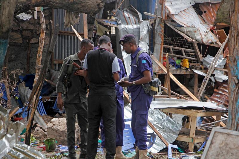 Security forces gather in the remains of destroyed houses after a suicide bomb attack in Mogadishu, Somalia Tuesday, Nov. 17, 2020. Police in Somalia say five people were killed when a suicide bomber detonated an explosives belt near the police academy in the capital, Mogadishu. (AP Photo/Farah Abdi Warsameh)