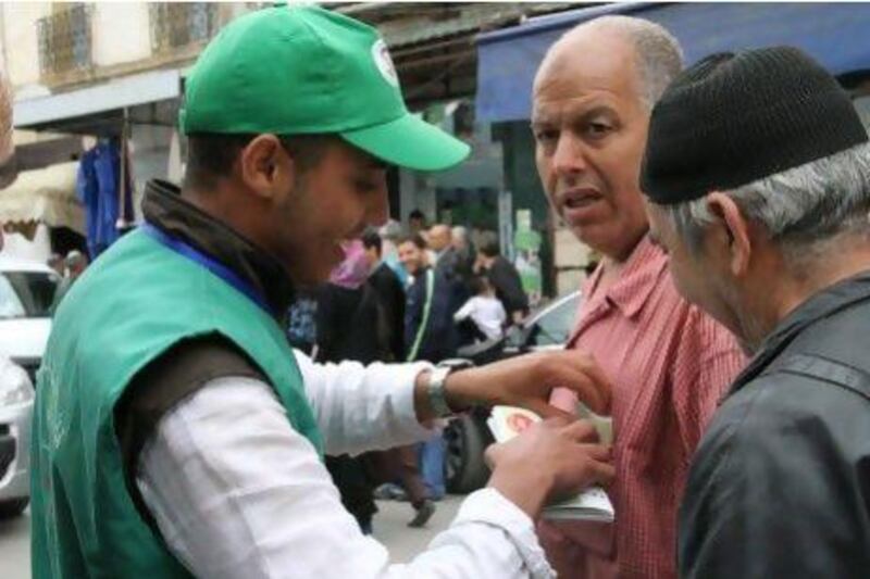 A campaign volunteer from the "Green" alliance of Islamist parties sticks a pamphlet in shirt pocket of a sceptical passer-by in the Harache neighbourhood of Algiers.