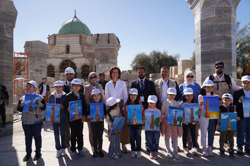 Unesco director general Audrey Azoulay poses with children and their paintings of Al Hadba minaret during her visit to Mosul. Ismael Adnan for The National