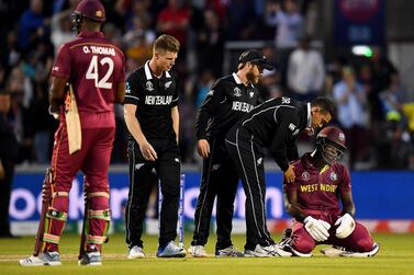 West Indies all-rounder Carlos Brathwaite is consoled by New Zealand players after defeat on Saturday. Clive Mason / Getty Images