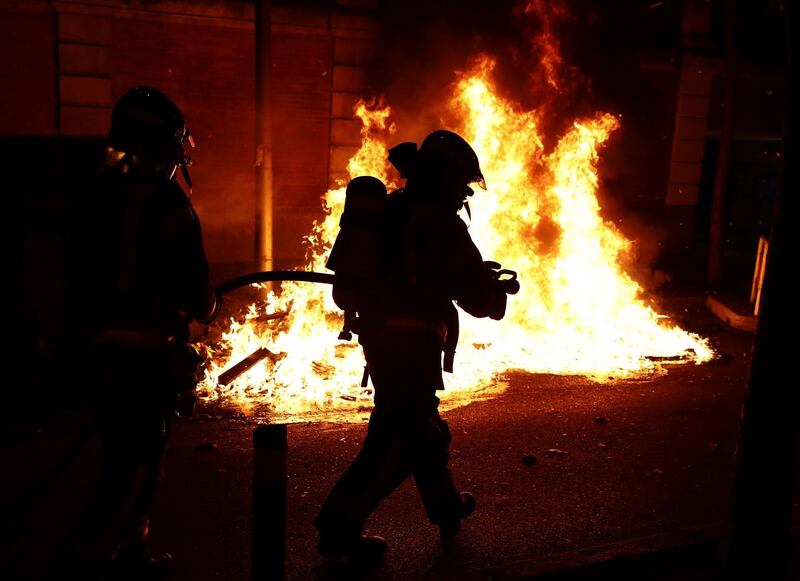 epa08790425 Firefighters extinguish containers and other items burned out by protesters trying to cut the Gran Via street in Madrid, central Spain, late 31 November 2020. Riots broke out in several cities in Spain in the the night to 01 November 2020, following protests against the new Government's restrictions, including curfews, to attenuate the curve of coronavirus contagions.  EPA/JAVIER LOPEZ