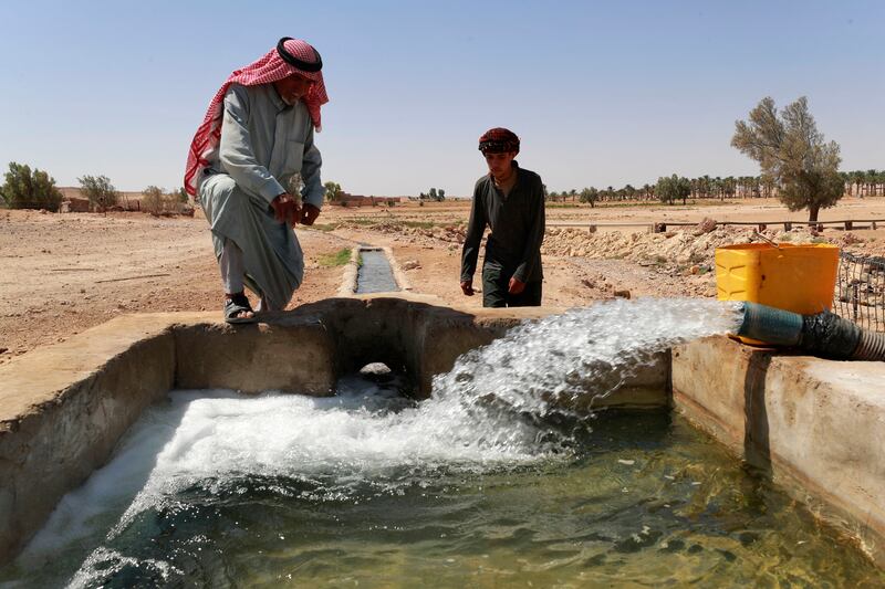 Abu Majid and a relative check on a water tank fed through a pump.