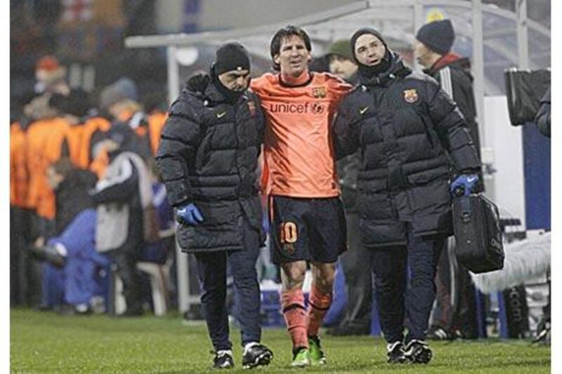 Lionel Messi, centre, is helped from the field against Dynamo Kiev.