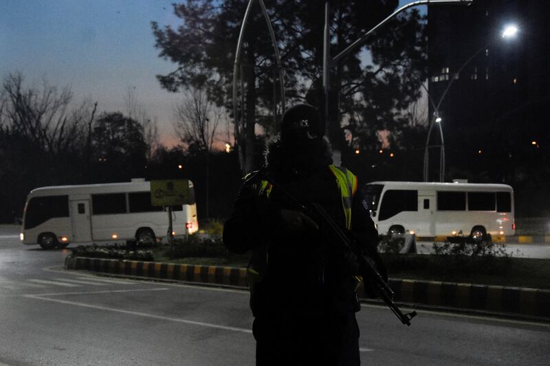 A police officer stands guard as vehicles carrying the Australian team pass by in Islamabad. Reuters