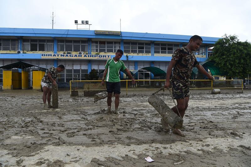 Members of the Nepali Army help clean mud left from floods which hit parts of Biratnagar's domestic airport. PRAKASH MATHEMA / AFP