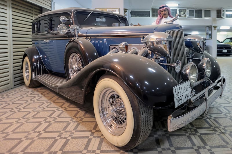 Nasser Al Masari stands behind one of his vintage cars.