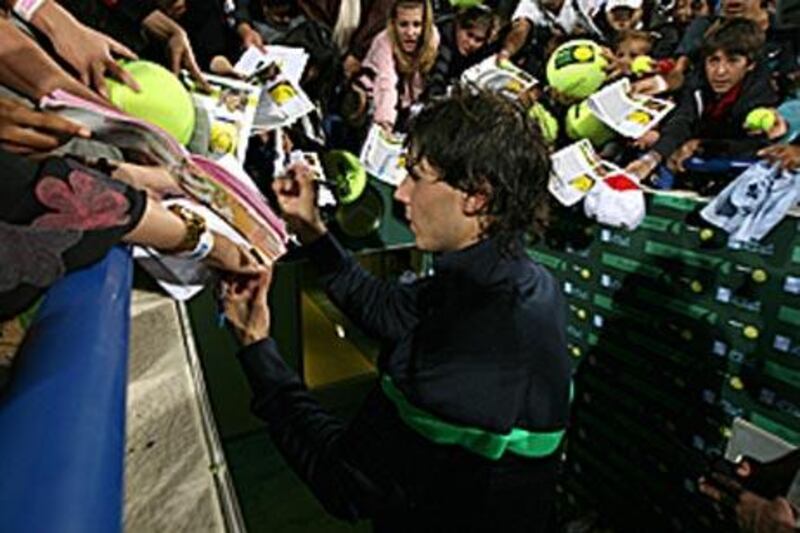 Rafael Nadal, who beat David Ferrer in straight sets last night, signs autographs on the second day of the Capitala tournament.