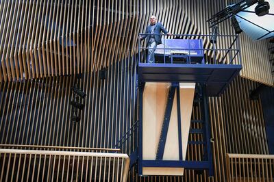 Piano constructor and builder David Klavins stands next to his new creation, the M470i vertical concert grand piano, with a height of 4,70 meters, at the new "Lativa" concert hall in Ventspils, Latvia, on July 23, 2019. Setting new musical heights, German-born innovator David Klavins has crafted what is believed to be the world's largest vertical piano that sits in a concert hall in Latvia. The piano is around three storeys above the audience. To reach the keys, pianists face a long uphill climb up a steep flight of steel stairs. / AFP / afp / Ilmars ZNOTINS
