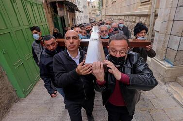 Christian worshippers carry a wooden cross along the Via Dolorosa (Way of Suffering) in Jerusalem's Old City during the Good Friday procession on April 2, 2021. AFP