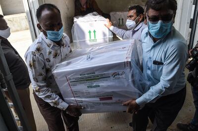 Officials unload boxes containing Covishield vaccine at the Regional Vaccine Store in Ahmedabad on January 12, 2021. / AFP / SAM PANTHAKY
