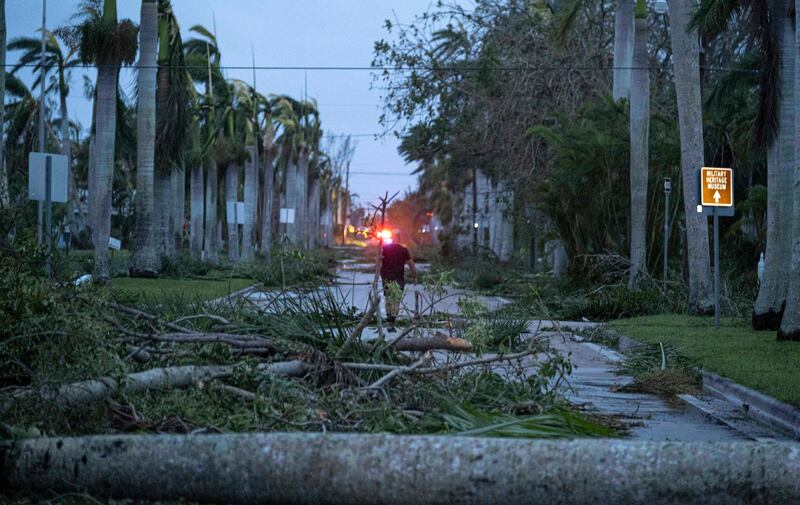 A man walks through debris on a street in the aftermath of Hurricane Ian in Punta Gorda, Florida. The storm left much of coastal south-west state in darkness early on Thursday and brought 'catastrophic' flooding. AFP