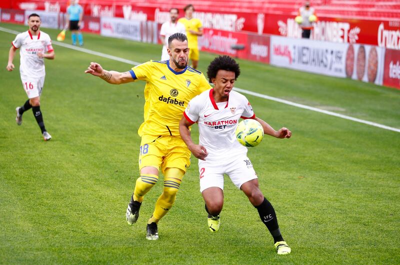 SEVILLE, SPAIN - JANUARY 23: Jules Kounde of Sevilla FC battles for possession with Alvaro Negredo of Cadiz CF during the La Liga Santander match between Sevilla FC and Cadiz CF at Estadio Ramon Sanchez Pizjuan on January 23, 2021 in Seville, Spain. Sporting stadiums around Spain remain under strict restrictions due to the Coronavirus Pandemic as Government social distancing laws prohibit fans inside venues resulting in games being played behind closed doors. (Photo by Fran Santiago/Getty Images)