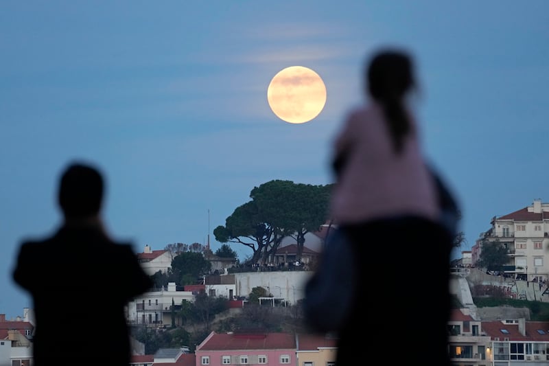 Stargazers in Lisbon, Portugal, marvel at the Wolf Moon. AP