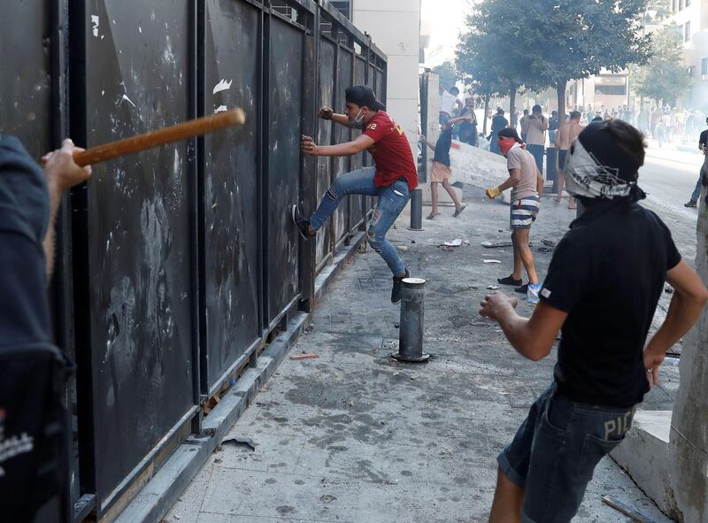 Demonstrators try to break a fence during a protest following Tuesday's blast in Beirut's port area. Reuters