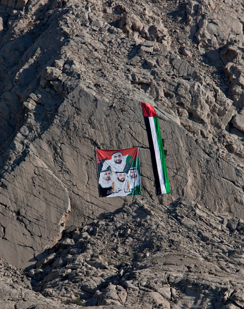 Ras al Khaimah, December 2, 2011 - Flags and faces of the country's leaders could be found on mountainsides, buildings and boulders along the highway from Ras al Khaimah City north to the Omani border in celebration of National Day in Ras al Khaimah, December 2, 2011.  (Jeff Topping/The National)