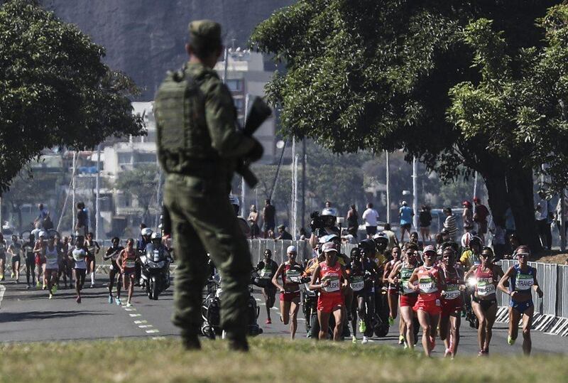 Competitors run along the road as a Brazilian soldier patrol the course during the women’s marathon race of the Rio 2016 Olympic Games in Rio de Janeiro, Brazil, 14 August 2016. Antonio Lacerda / EPA