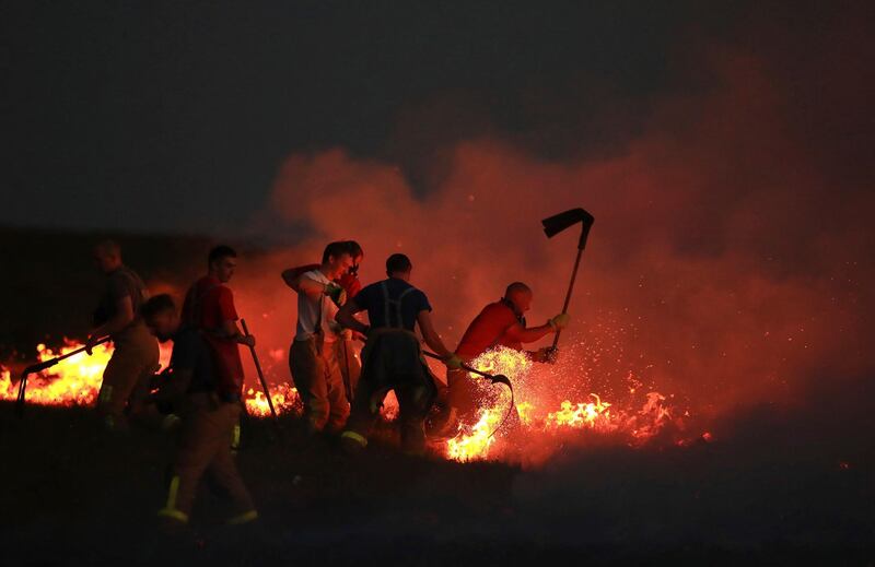 Firefighters tackle a wildfire on Winter Hill near Bolton, England. Danny Lawson / PA via AP
