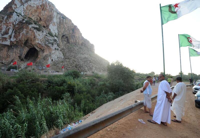 People stand on the Algerian side of the Algeria-Morocco border as Algerian flags sway in the wind and Moroccan flags are seen in the distance, near Tlemcen, at a border post in the Marsat Ben M'Hidi region. Farouk Batiche / AFP