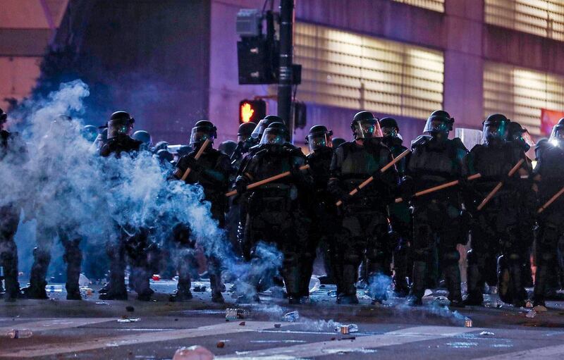 Police in riot gear form a line near the Centennial Olympic Park and CNN centre in Atlanta, Georgia. Atlanta Journal-Constitution via AP