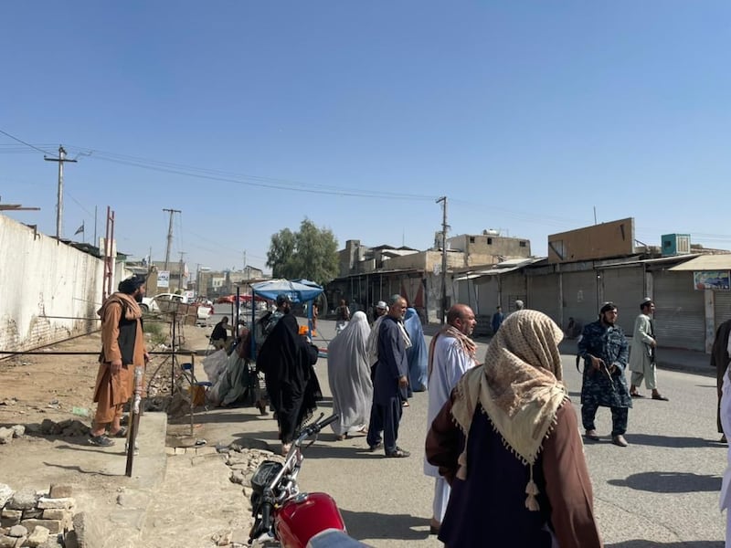 Kandahar residents gather at the scene of the blast.
