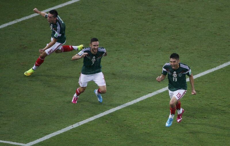 Mexico's Oribe Peralta, right, celebrates his goal on Friday with teammates Hector Herrera, left and Miguel Layun during their 1-0 win over Cameroon at the 2014 World Cup in Natal, Brazil. Carlos Barria / Reuters