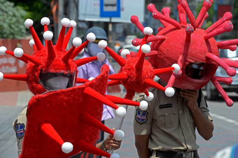 Police at a traffic intersection wearing headgear themed on the Covid-19 coronavirus urge people to adopt safety protocols during an awareness drive in Hyderabad. AFP