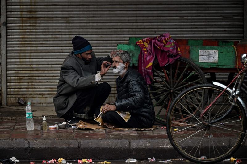 A migrant labourer has a shave in the old quarters of Delhi’s walled city. The Indian capital has imposed a  state-wide weekend curfew to curb cases of Covid-19. AFP