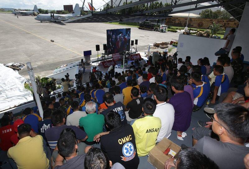 Filipino troopers and aid workers watch the match as it begins at Villamor air base in Pasay, Philippines on Sunday. Aaron Favila / AP