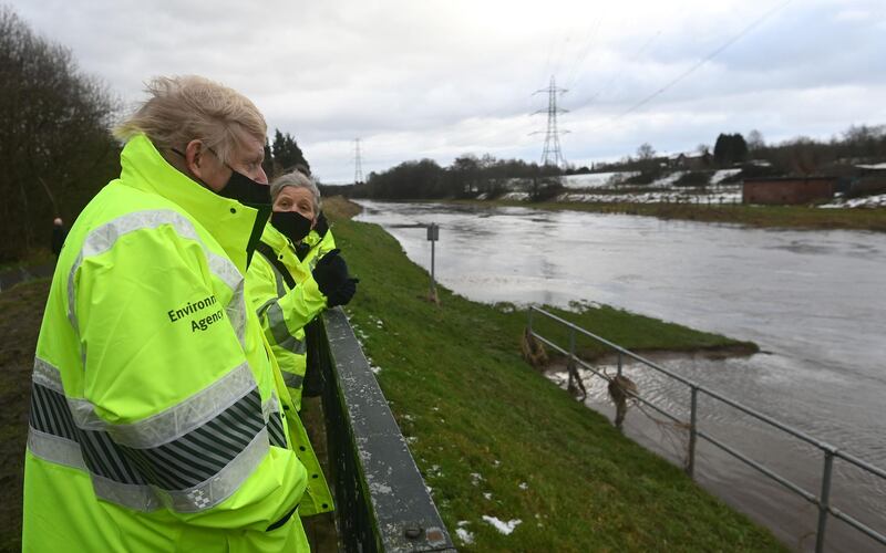 Boris Johnson looks at River Mersey in Didsbury with Environment Agency workers, as Storm Christoph brings heavy rains across the country. AFP