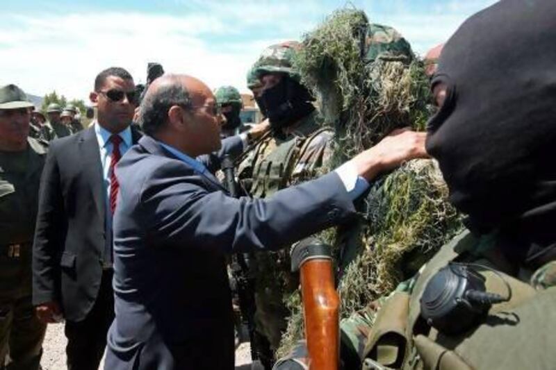 The Tunisian president, Moncef Marzouki, centre, greets a soldier at a military camp in the border region with Algeria. AFP