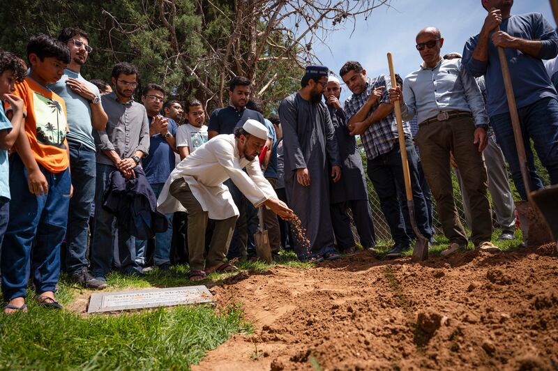 Mourners sprinkle dirt over the grave of Muhammad Afzaal. The Albuquerque Journal / AP