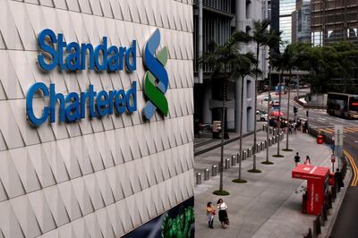 FILE PHOTO: People walk outside the main branch of Standard Chartered in Hong Kong, China August 1, 2017. REUTERS/Bobby Yip/File Photo