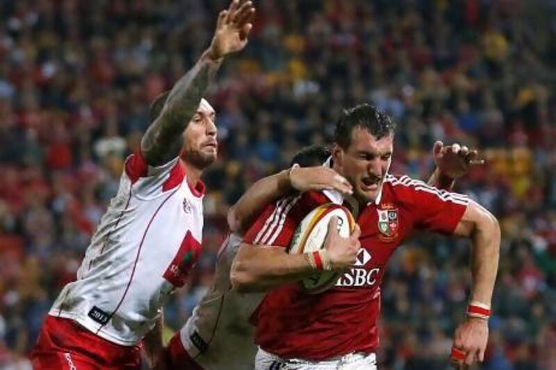British and Irish Lions' Sam Warburton is tackled by Queensland Reds' Quade Cooper.