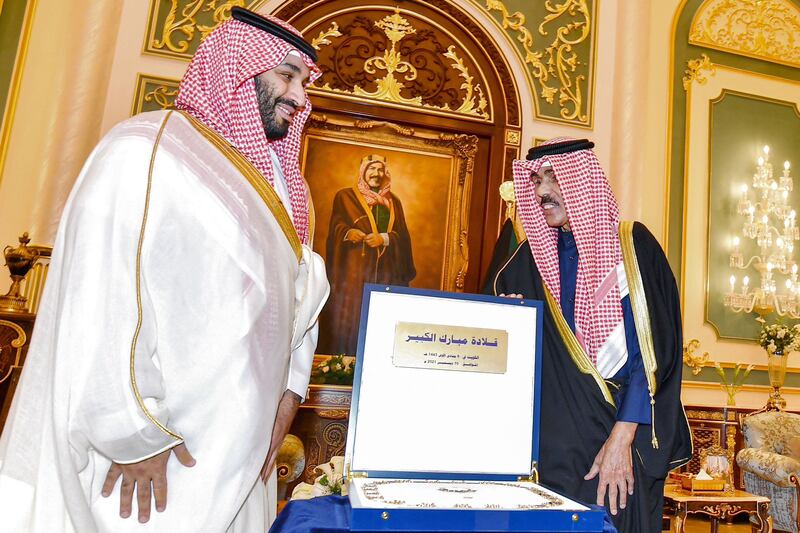 Emir Sheikh Nawaf bestows Saudi Arabia's Crown Prince Mohammed bin Salman with the Order of Mubarak the Great during their meeting in Kuwait City on December 10, 2021. AFP