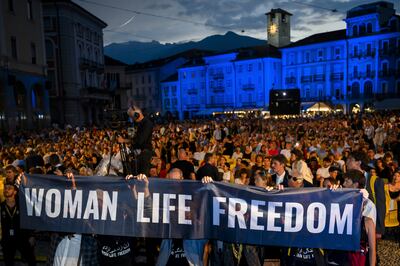 Crew members of Mantagheye bohrani carry a "Woman Life Freedom" banner to celebrate the film's Golden Leopard award win at the Locarno International Film Festival. AP