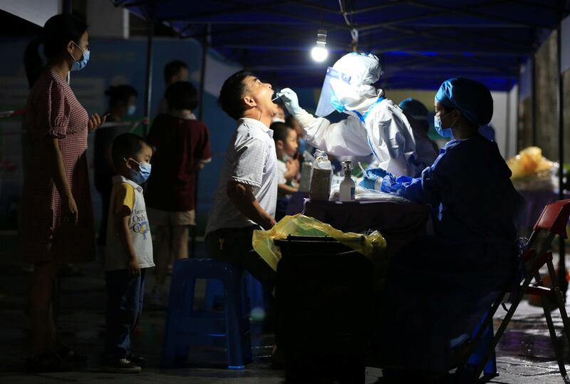 A medical worker collects a swab from a man for nucleic acid testing in Xiangzhou district of Zhuhai in Guangdong province, China. Reuters